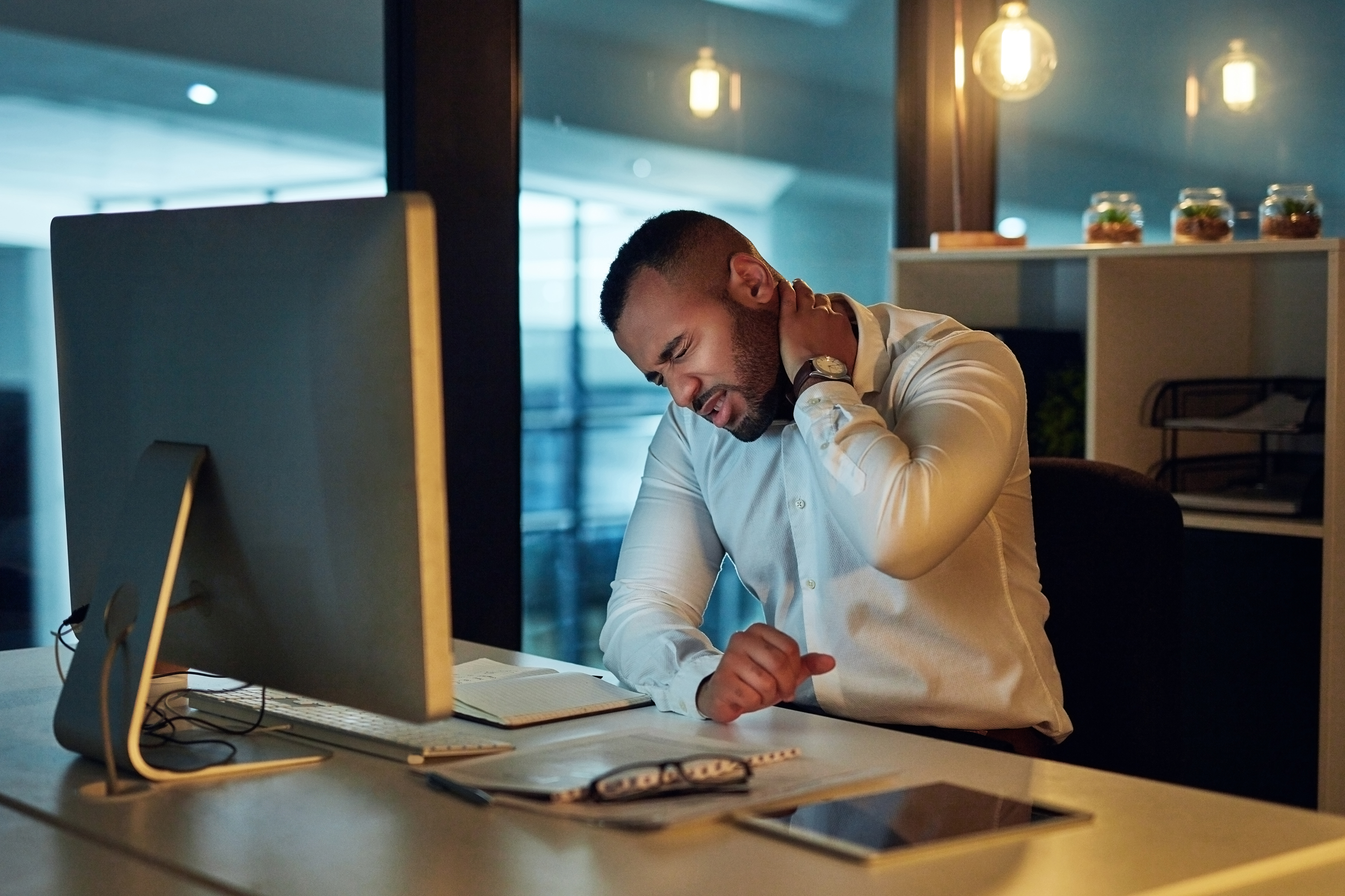 Man with neck pain at computer desk 